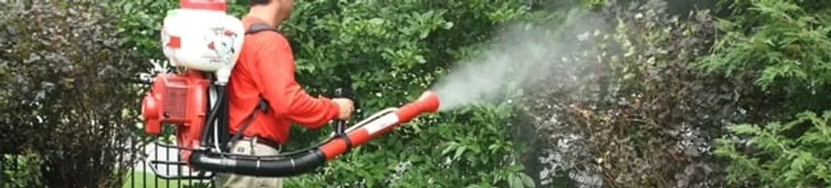 Mosquito control technician fogging shrubs and landscaping for mosquito treatment in Ogden, UT