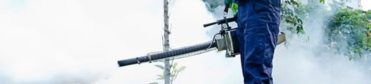 Pest control technician fogging an outdoor area for insect control in Ogden, UT