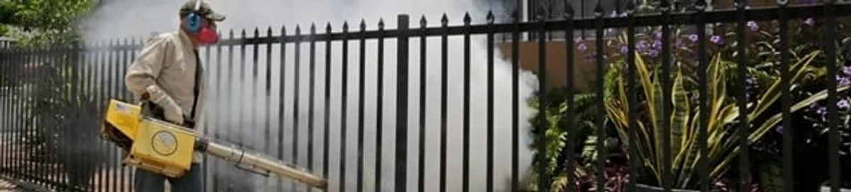 Mosquito control technician fogging a yard perimeter for mosquito reduction in Ogden, UT